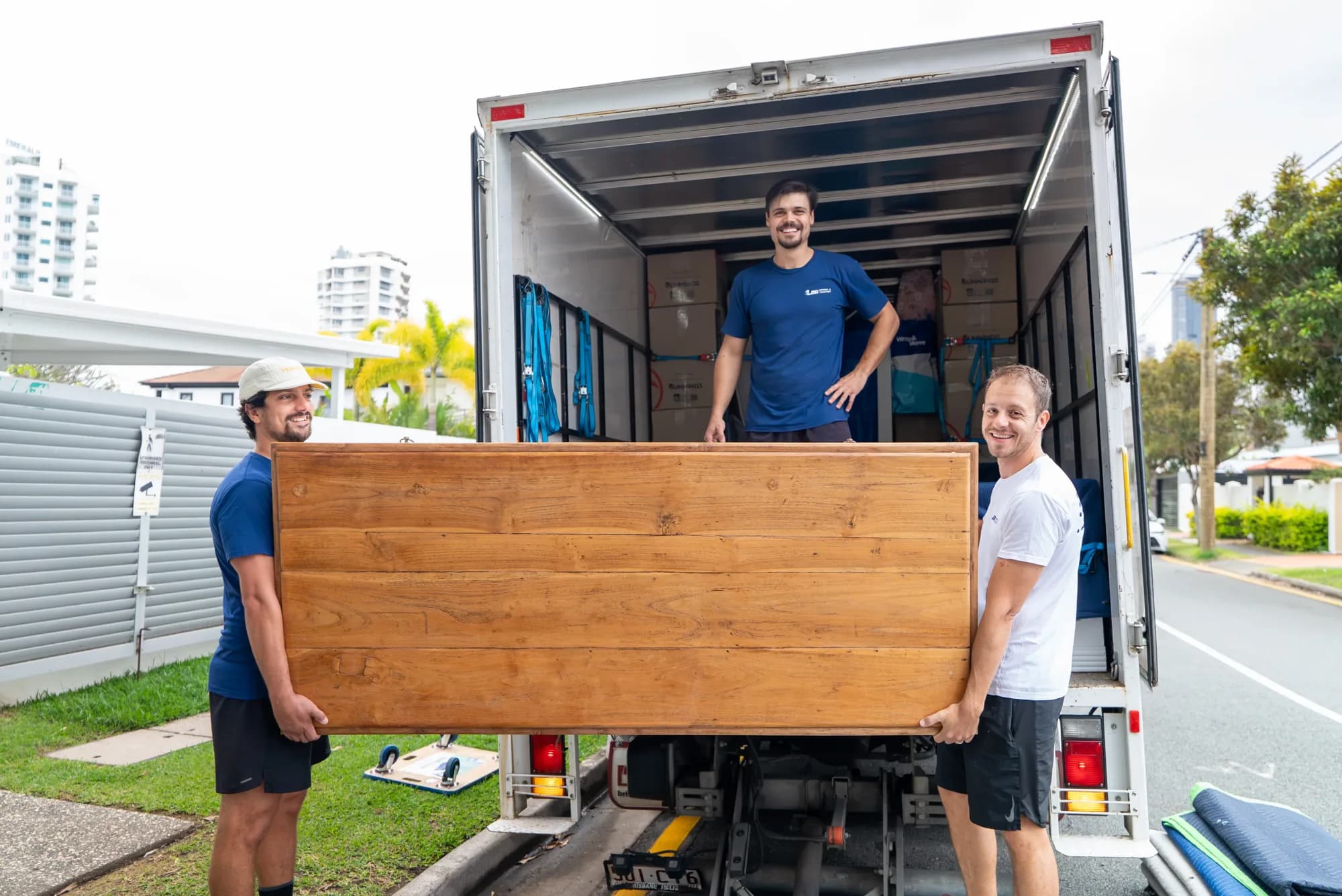 LOG Transport team carrying a large timber table at the truck